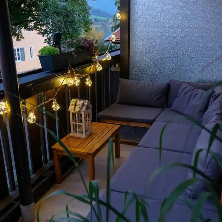 Abendstimmung in der Lounge-Ecke auf dem Balkon mit seitlichem Blick auf den See, © Ferienwohnung Auszeit am See