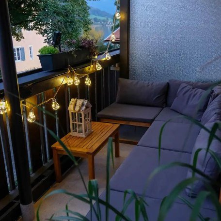 Abendstimmung in der Lounge-Ecke auf dem Balkon mit seitlichem Blick auf den See, © Ferienwohnung Auszeit am See