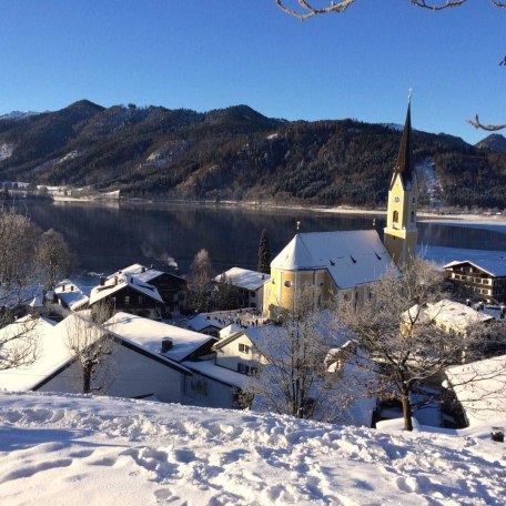 Blick auf das Haus (rechts neben der Kirche) im Winter, © im-web.de/ Gäste-Information Schliersee in der vitalwelt schliersee